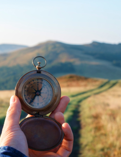 Person holding a compass, looking down at a pathway through the grass. The Pathways to Online Learning course lets you choose your teaching style.
